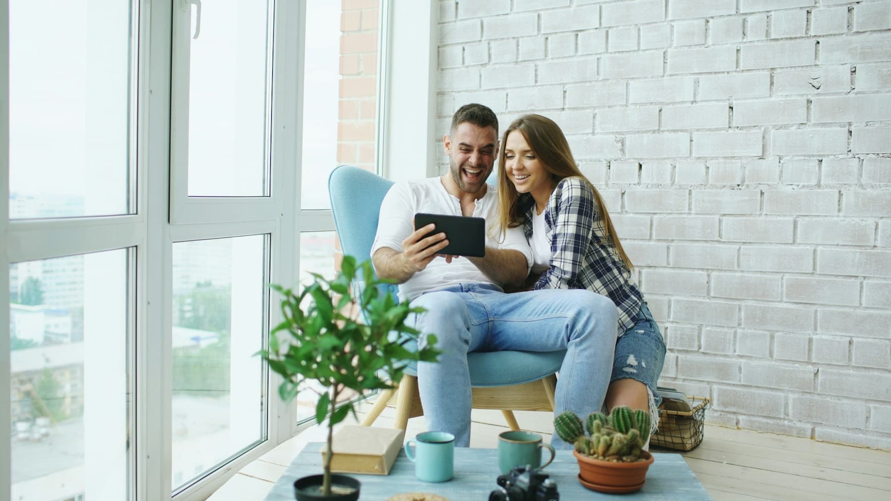 Stel ontspant samen in een lichte woonkamer met tablet