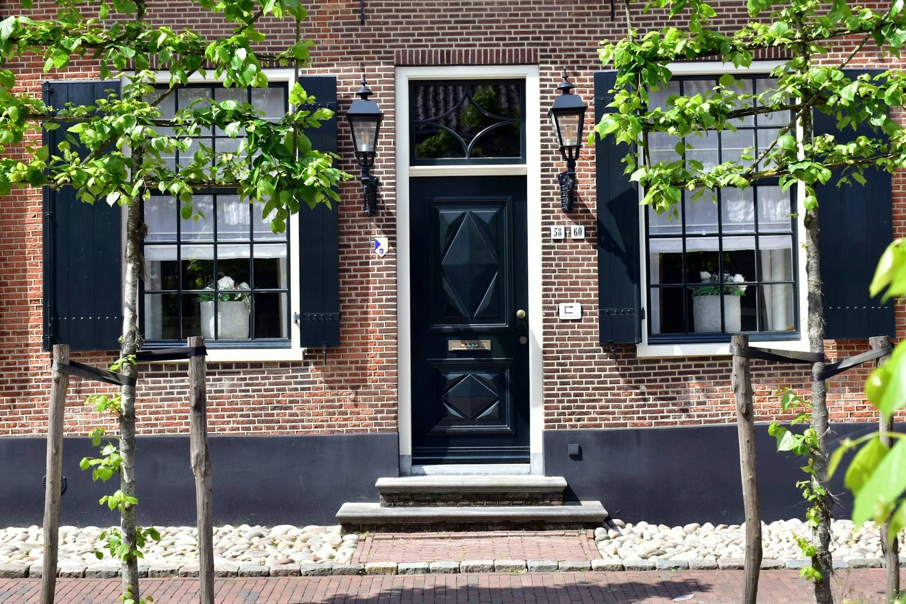 Voorgevel van een Nederlands bakstenen huis met zwarte voordeur