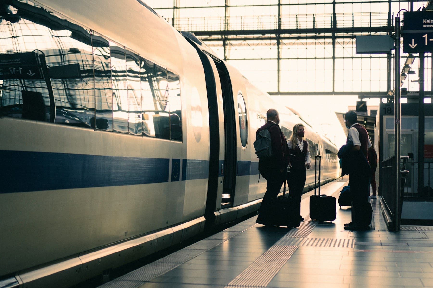 Reizigers met koffers op het perron naast een trein